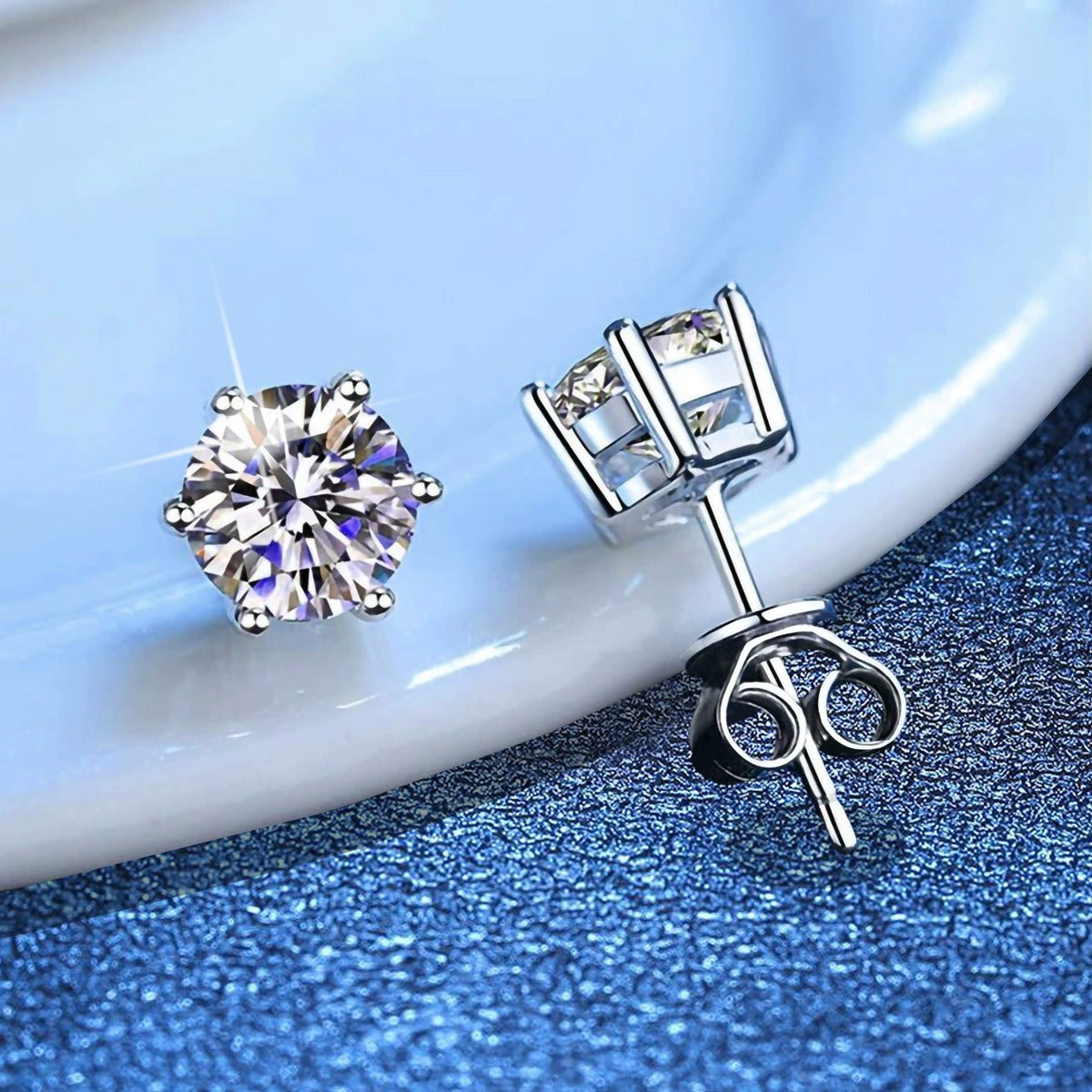 Round Moissanite Stud Earrings in White Gold-Plated S925 Sterling Silver blue scene close-up view