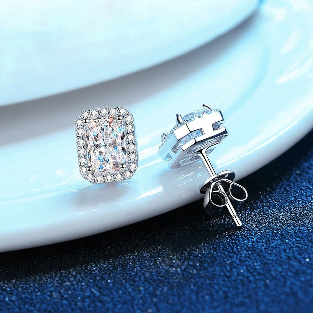 Emerald and Radiant Cut Moissanite Stud Earrings with CZ in S925 Silver blue scene angled view