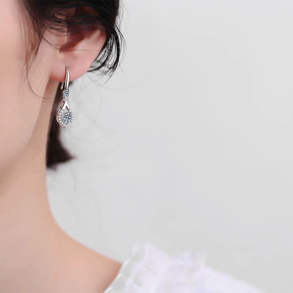 Pear Moissanite Drop Earrings with CZ in White Gold-Plated S925 worn on ear by model