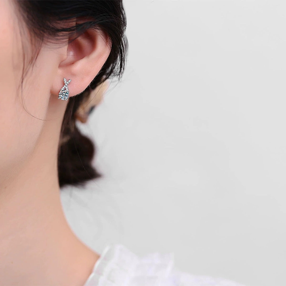 Ribbon Moissanite Stud Earrings with CZ in White Gold-Plated S925 worn on ear by model