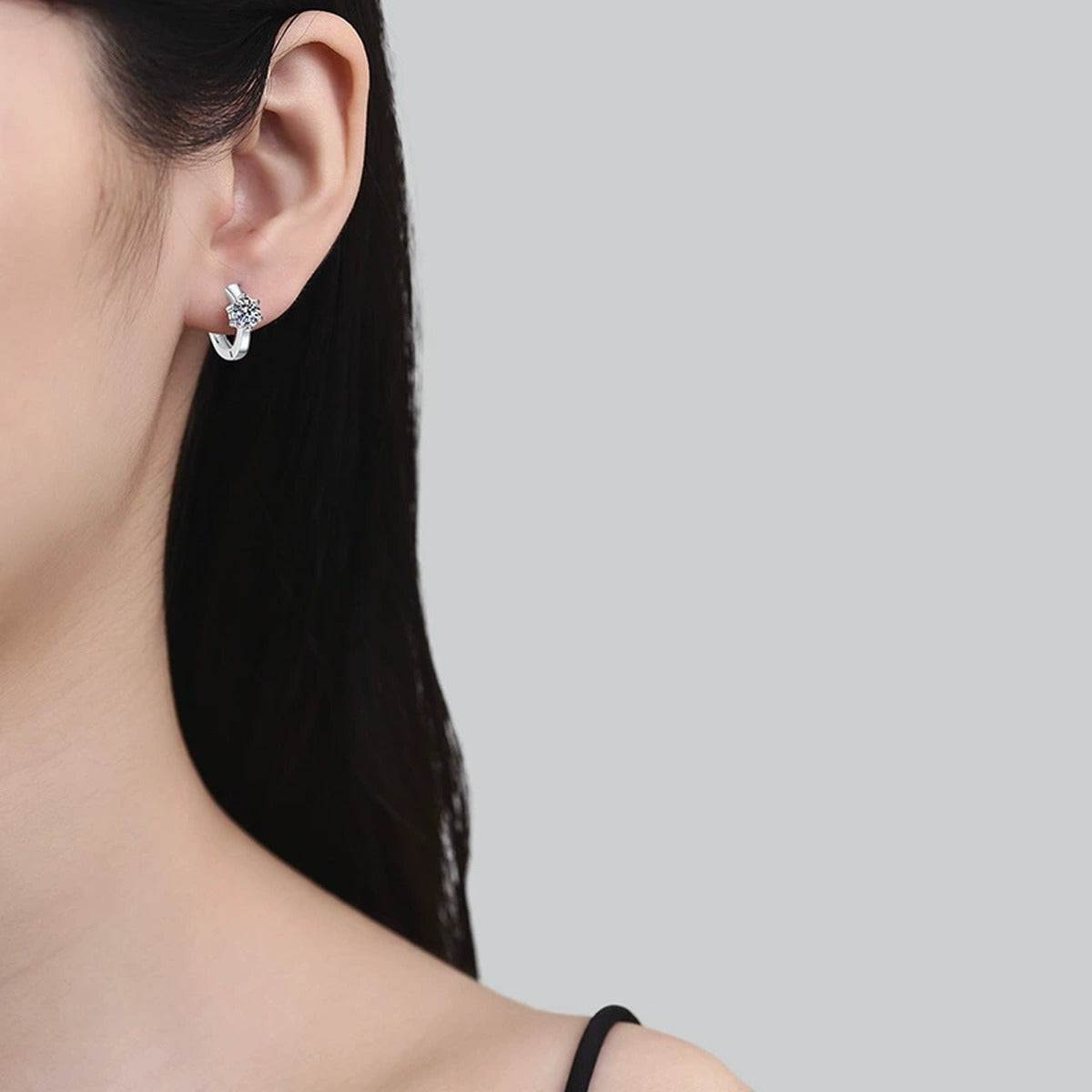 Round Moissanite Huggie Earrings in White Gold-Plated S925 Silver worn on ear by model