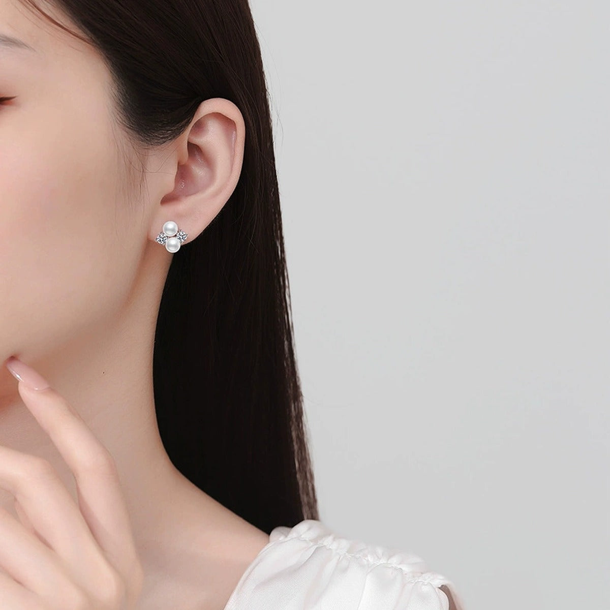 Pearl Moissanite Stud Earrings in White Gold-Plated S925 Sterling Silver worn on ear by model