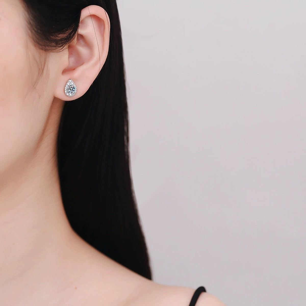 Pear Moissanite Stud Earrings with CZ in White Gold-Plated S925 Silver worn on ear by model