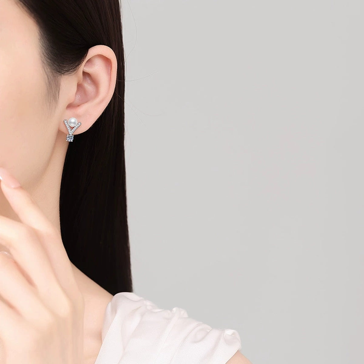 V-Shaped Pearl Moissanite Stud Earrings with CZ in White Gold-Plated S925 Sterling Silver worn on ear by model