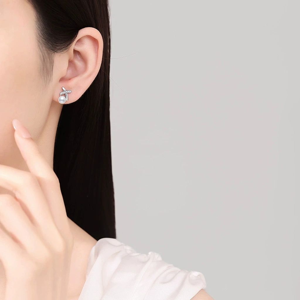 Cross Pearl Stud Earrings with CZ in White Gold-Plated S925 Sterling Silver worn on ear by model