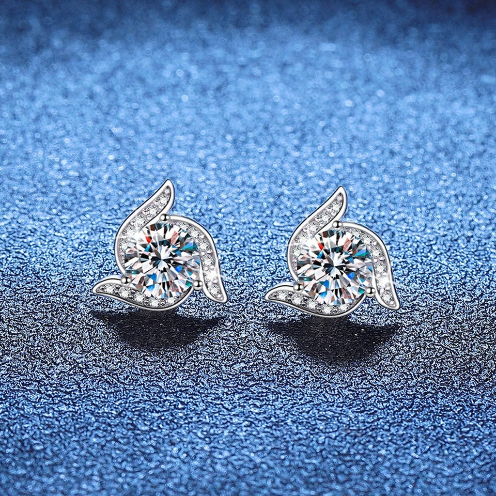 Pair of leaf round moissanite stud earrings on blue textured background