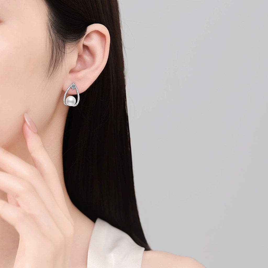 Pear-Shaped Pearl Moissanite Stud Earrings with CZ in White Gold-Plated S925 Sterling Silver worn on ear by model