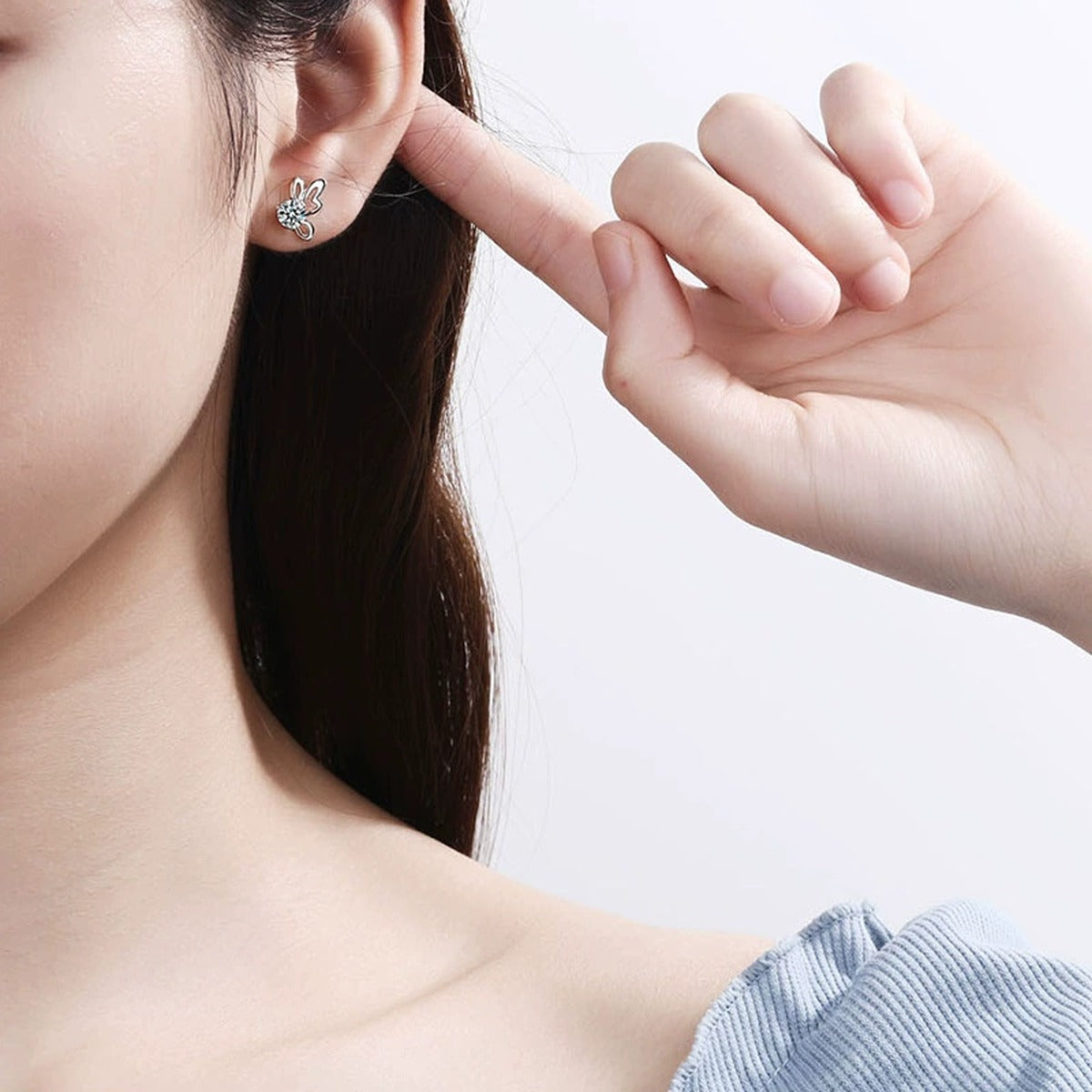 Butterfly Moissanite Stud Earrings in White Gold-Plated S925 Sterling Silver worn on ear by model