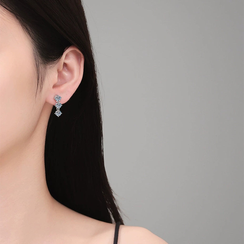 Three-Stone Moissanite Stud Earrings in White Gold-Plated S925 Sterling Silver worn on ear by model