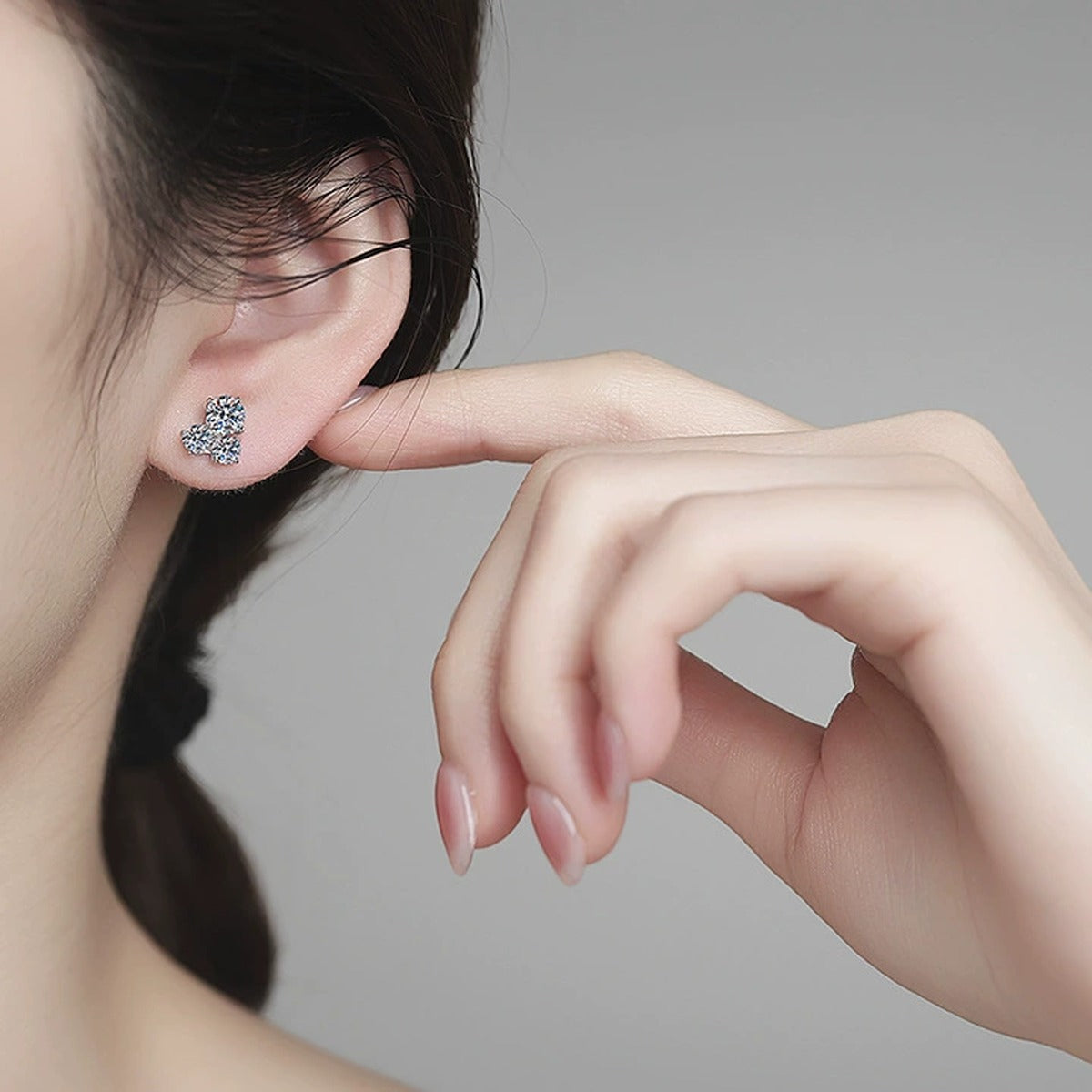 Three-Stone Moissanite Stud Earrings in White Gold-Plated S925 Sterling Silver worn on ear by model