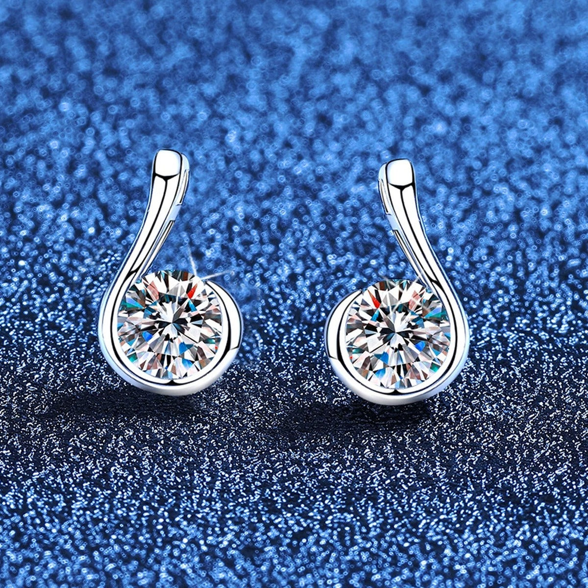 Curved Teardrop Moissanite Stud Earrings in White Gold-Plated S925 Sterling Silver blue scene angled view