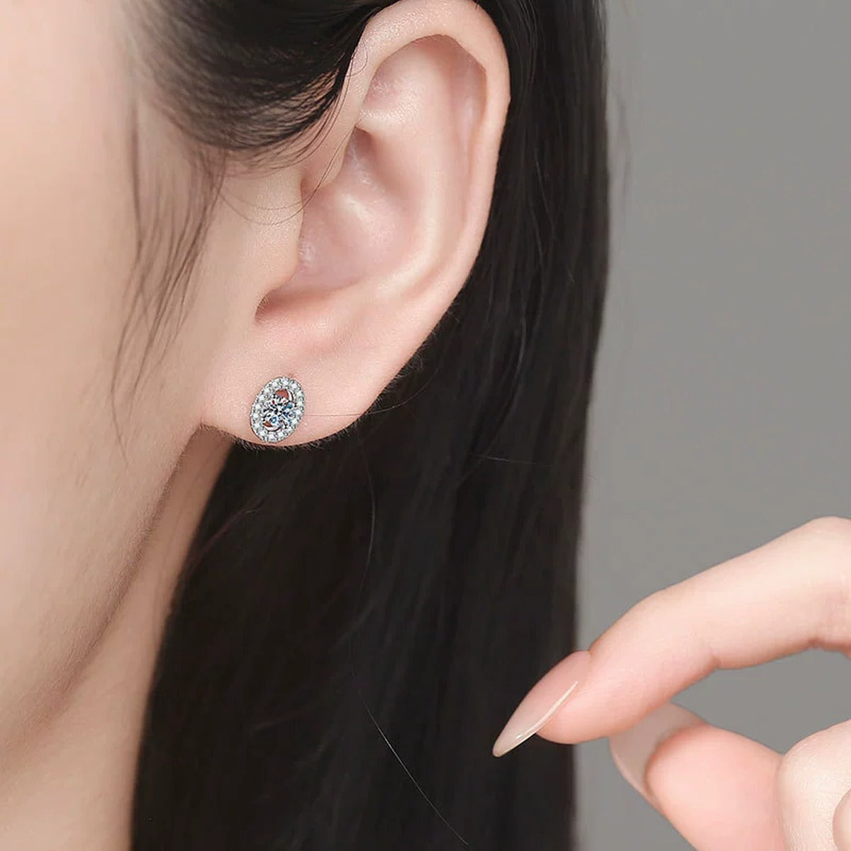 Oval Halo Moissanite Stud Earrings with CZ in White Gold-Plated S925 Sterling Silver worn on ear by model