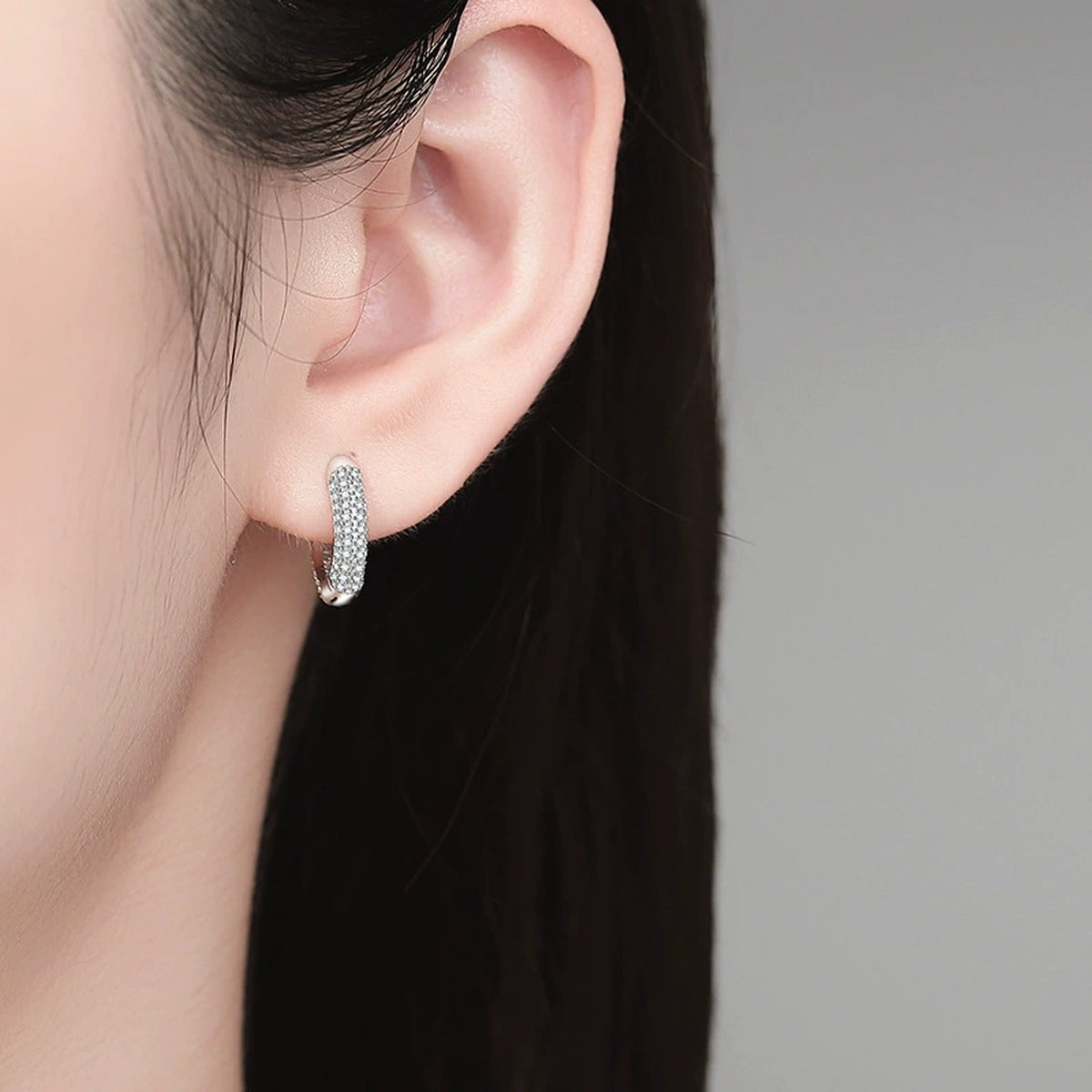 Pave Moissanite Huggie Hoop Earrings in White Gold-Plated S925 Sterling Silver worn on ear by model