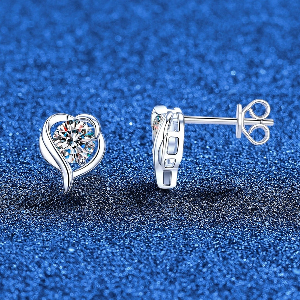 Swirl Heart Moissanite Stud Earrings in White Gold-Plated S925 Sterling Silver blue scene angled view