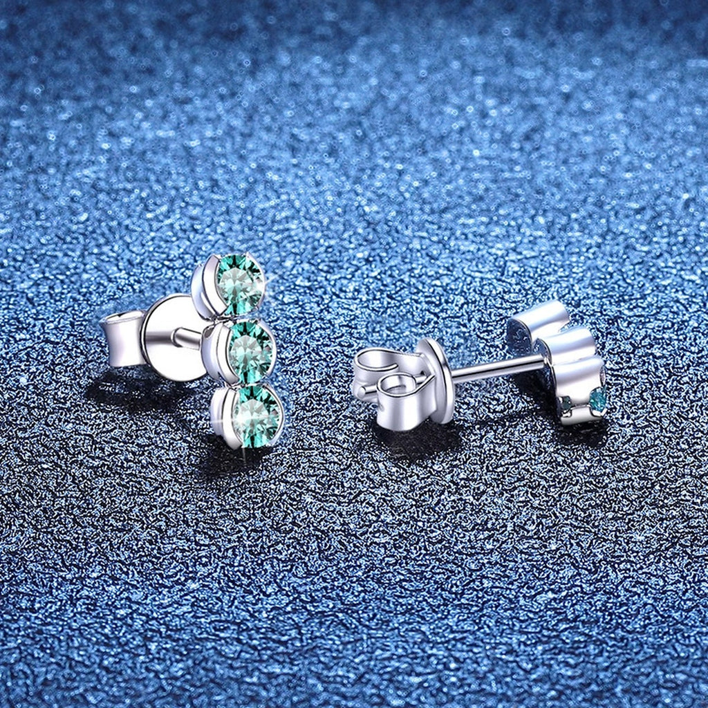 Green Moissanite Three-Stone Stud Earrings in White Gold-Plated S925 Sterling Silver blue scene close-up view