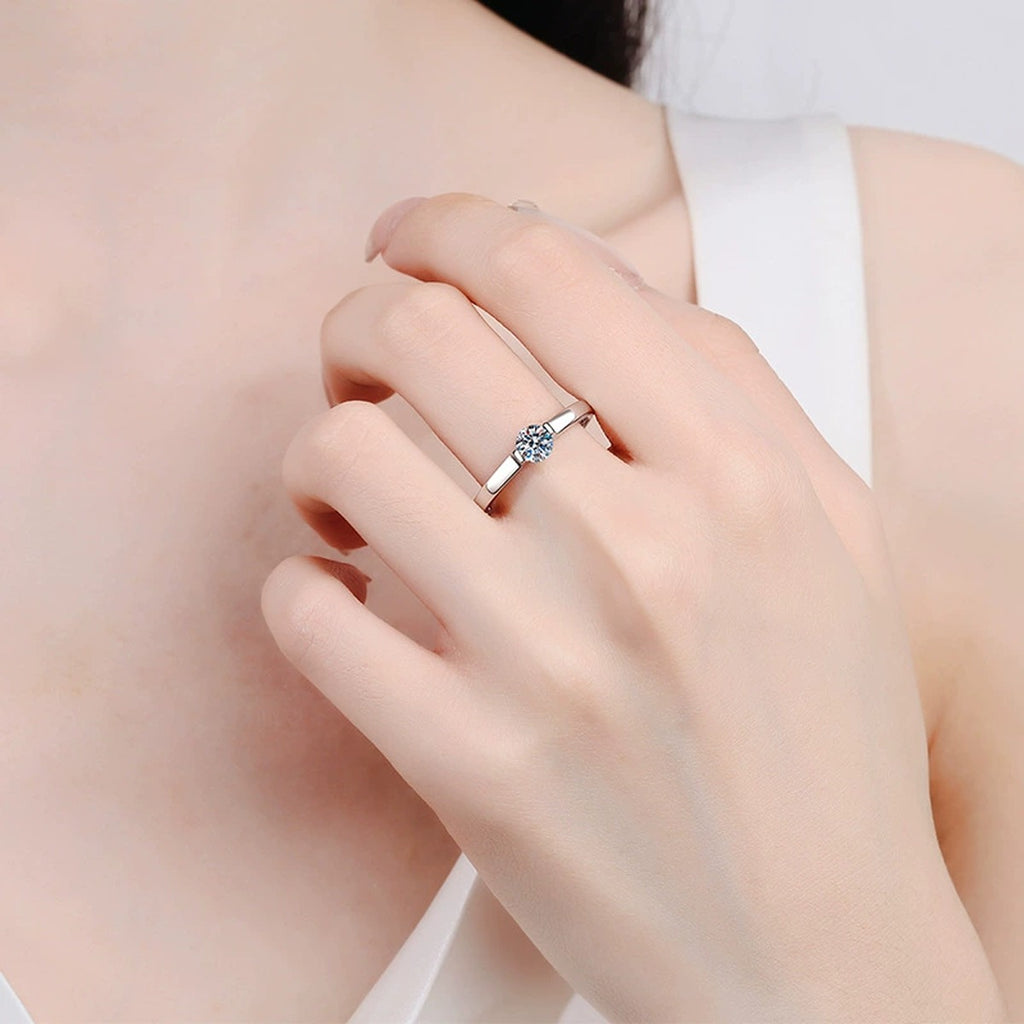 Round Solitaire Moissanite Engagement Ring worn on hand by model