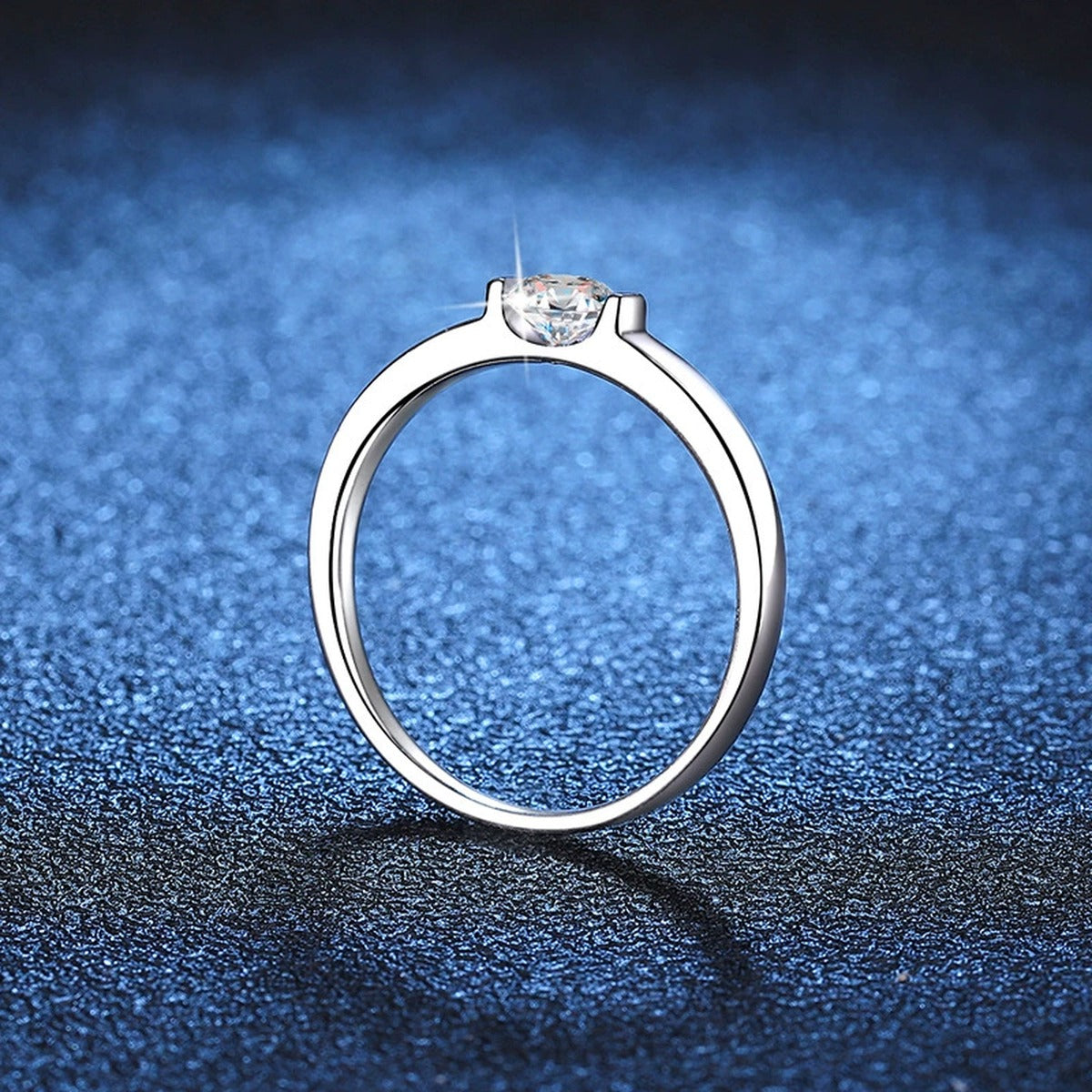 Round Solitaire Moissanite Engagement Ring blue background product view