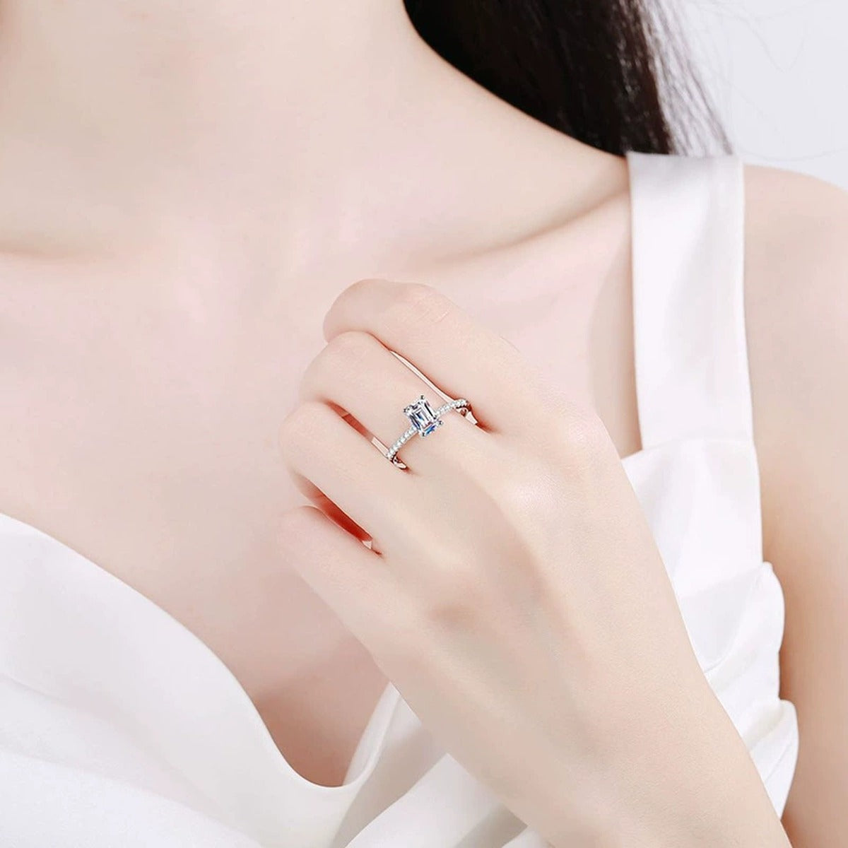 Emerald and Radiant Cut Moissanite Ring with CZ worn on hand by model