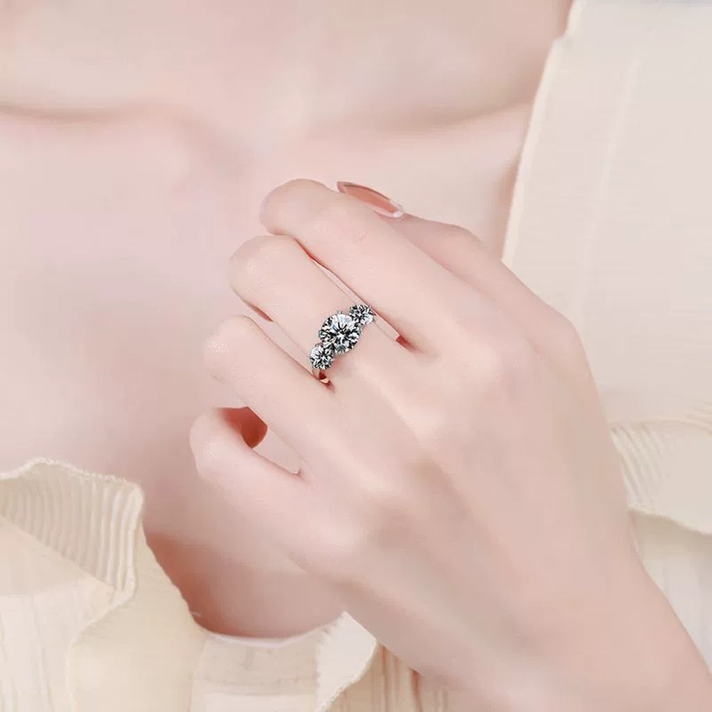 Three Stone Moissanite Engagement Ring worn on hand by model