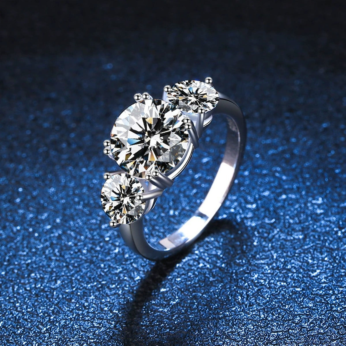 Three Stone Moissanite Engagement Ring blue background product view
