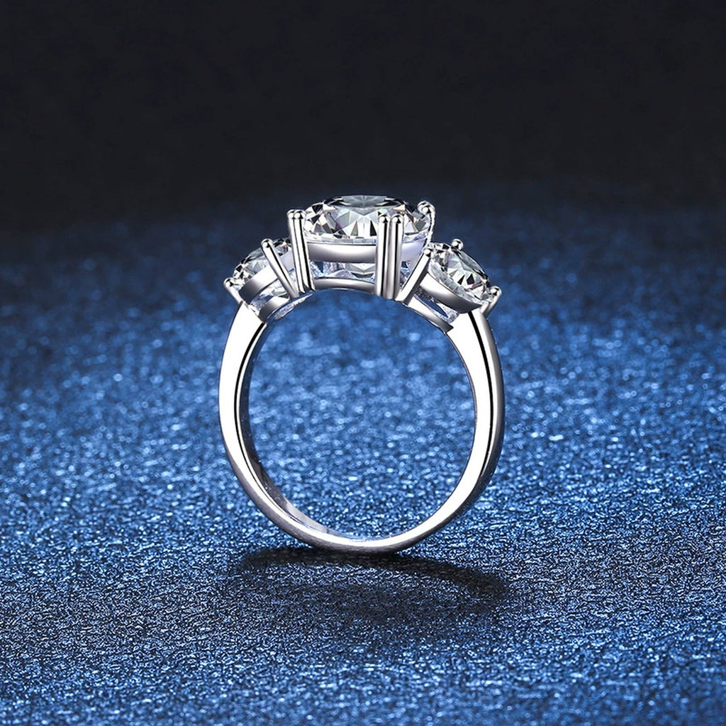 Three Stone Moissanite Engagement Ring blue background product view