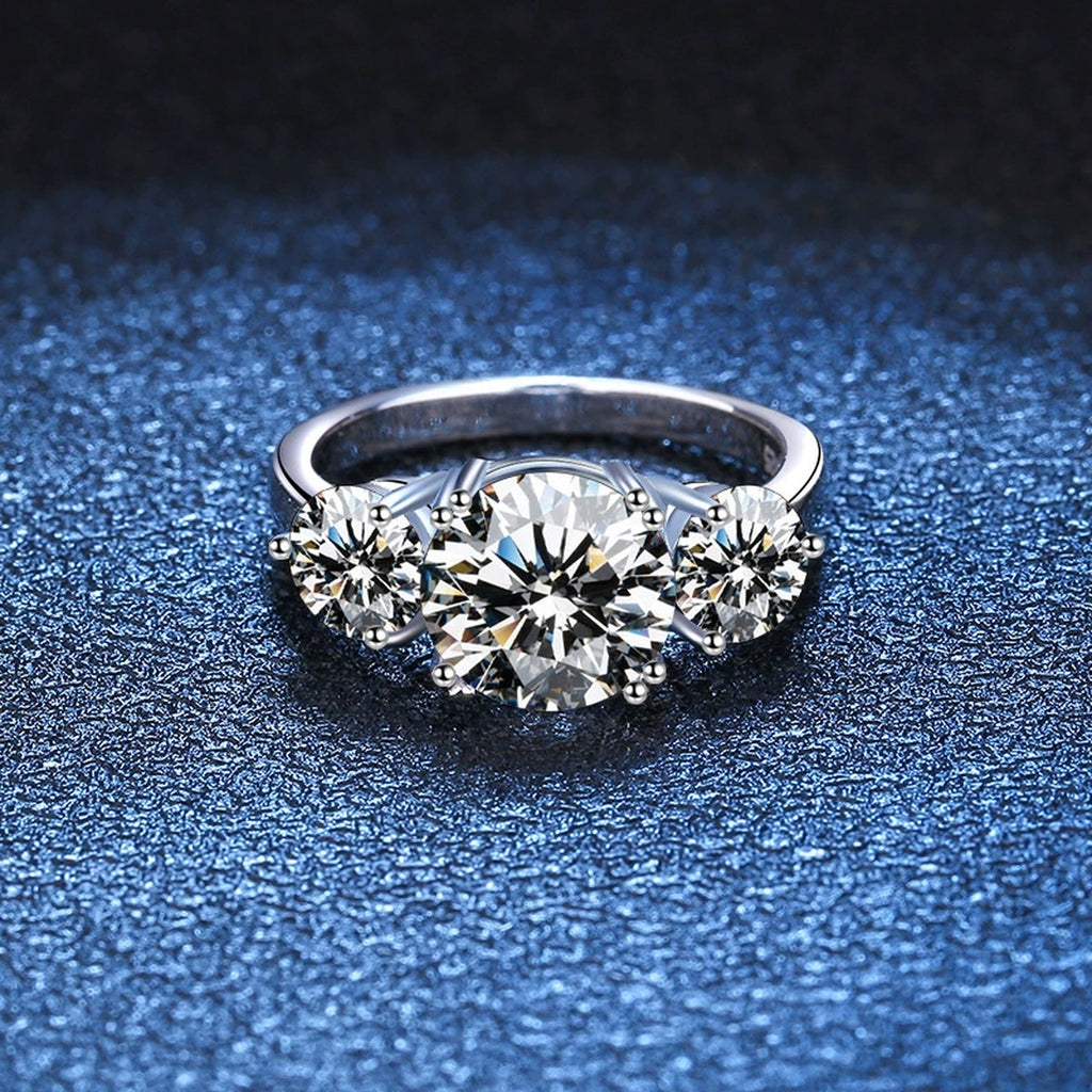 Three Stone Moissanite Engagement Ring blue background product view