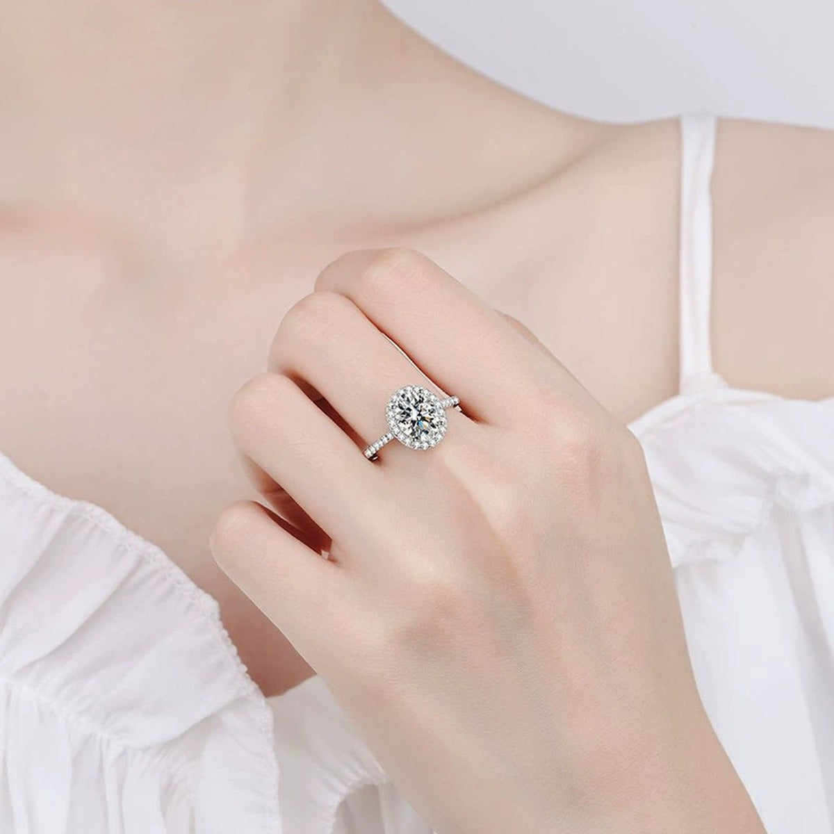 Oval Halo Moissanite Engagement Ring with CZ worn on hand by model