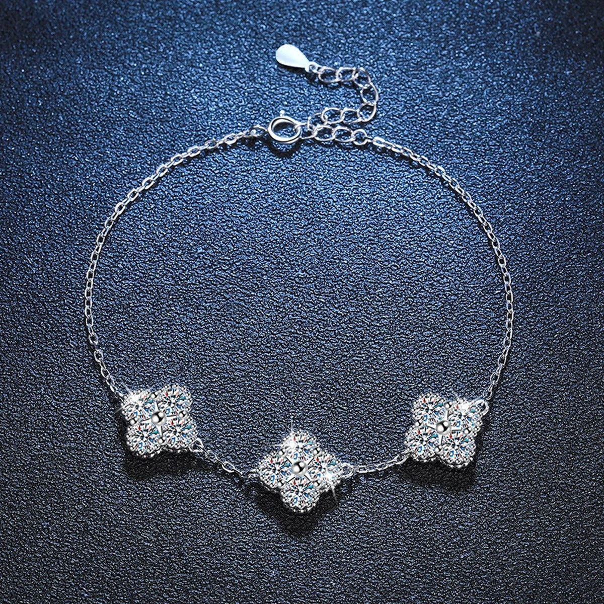 Three-Stone Cushion Moissanite Chain Bracelet in White Gold-Plated S925 Sterling Silver blue display scene showing bracelet sparkle and chain detail