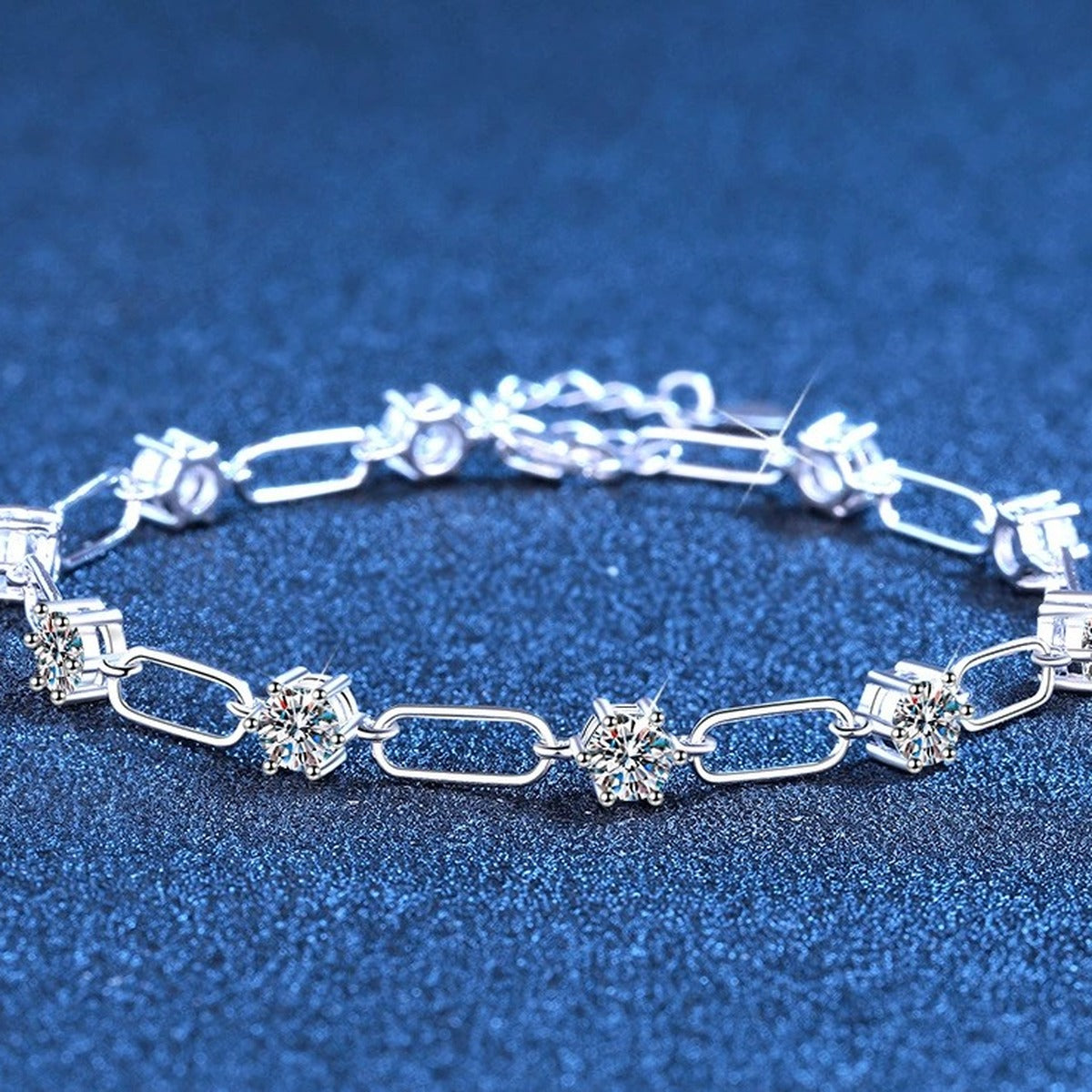 Three-Stone Moissanite Chain Bracelet in White Gold-Plated S925 Sterling Silver blue display scene showing bracelet sparkle and chain detail