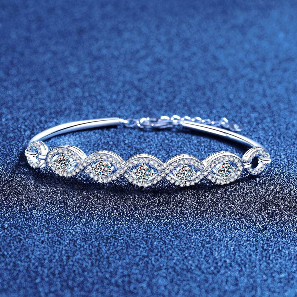 Oval Moissanite Bangle Bracelet with CZ styled on blue display background showing moissanite sparkle and chain detail