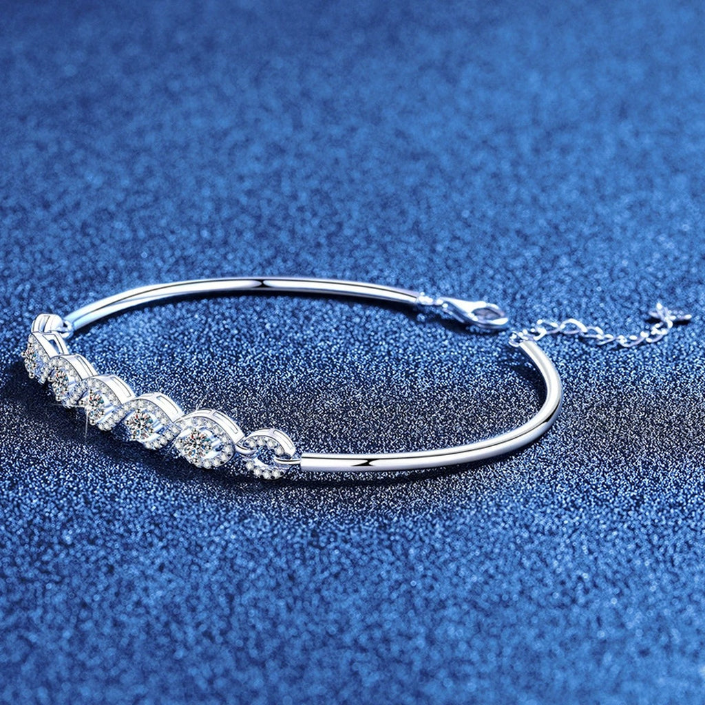 Oval Moissanite Bangle Bracelet with CZ styled on blue display background showing moissanite sparkle and chain detail