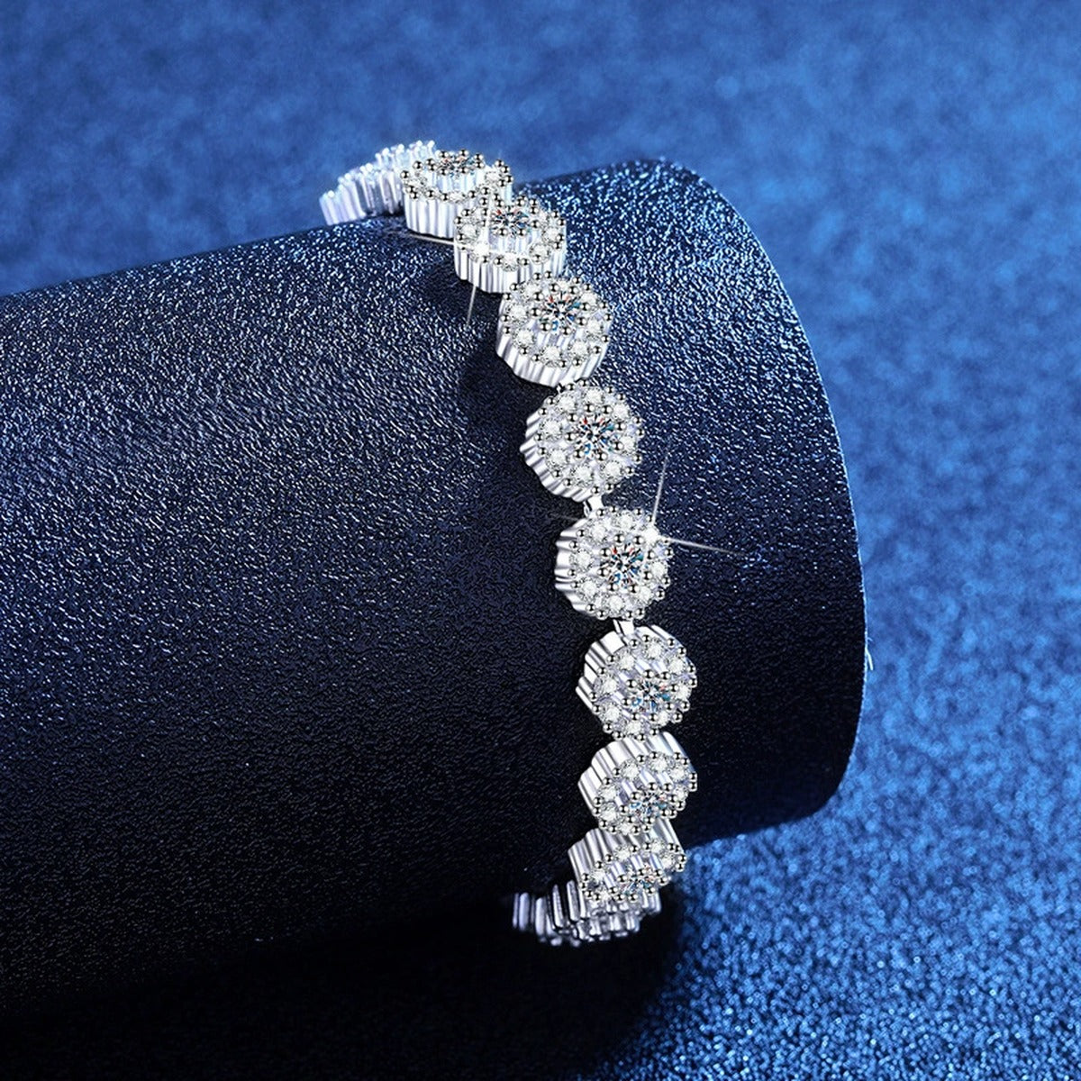 Round Moissanite Tennis Bracelet with CZ styled on blue display background showing moissanite sparkle and chain detail