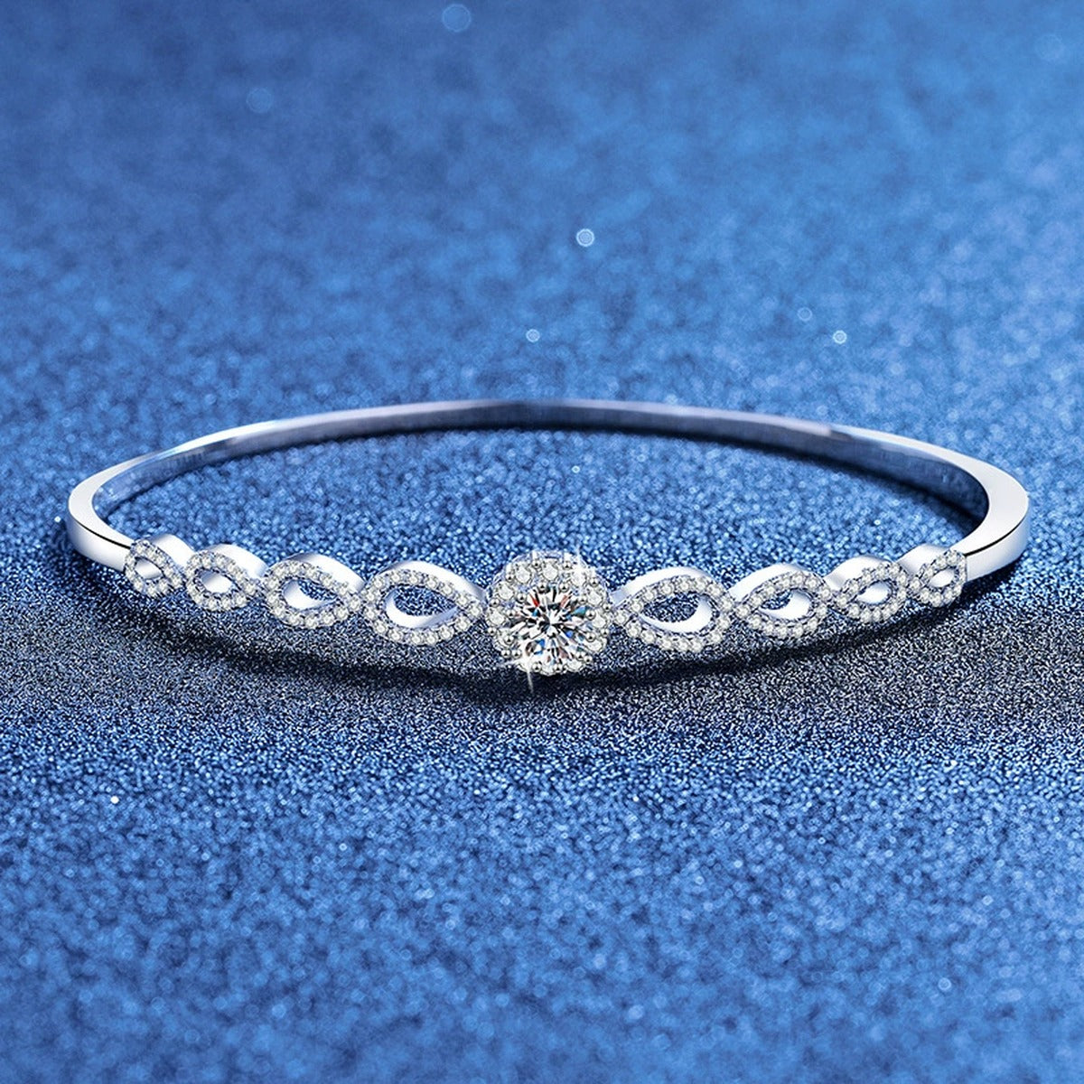 Round Moissanite Bangle Bracelet with CZ styled on blue display background showing moissanite sparkle and chain detail