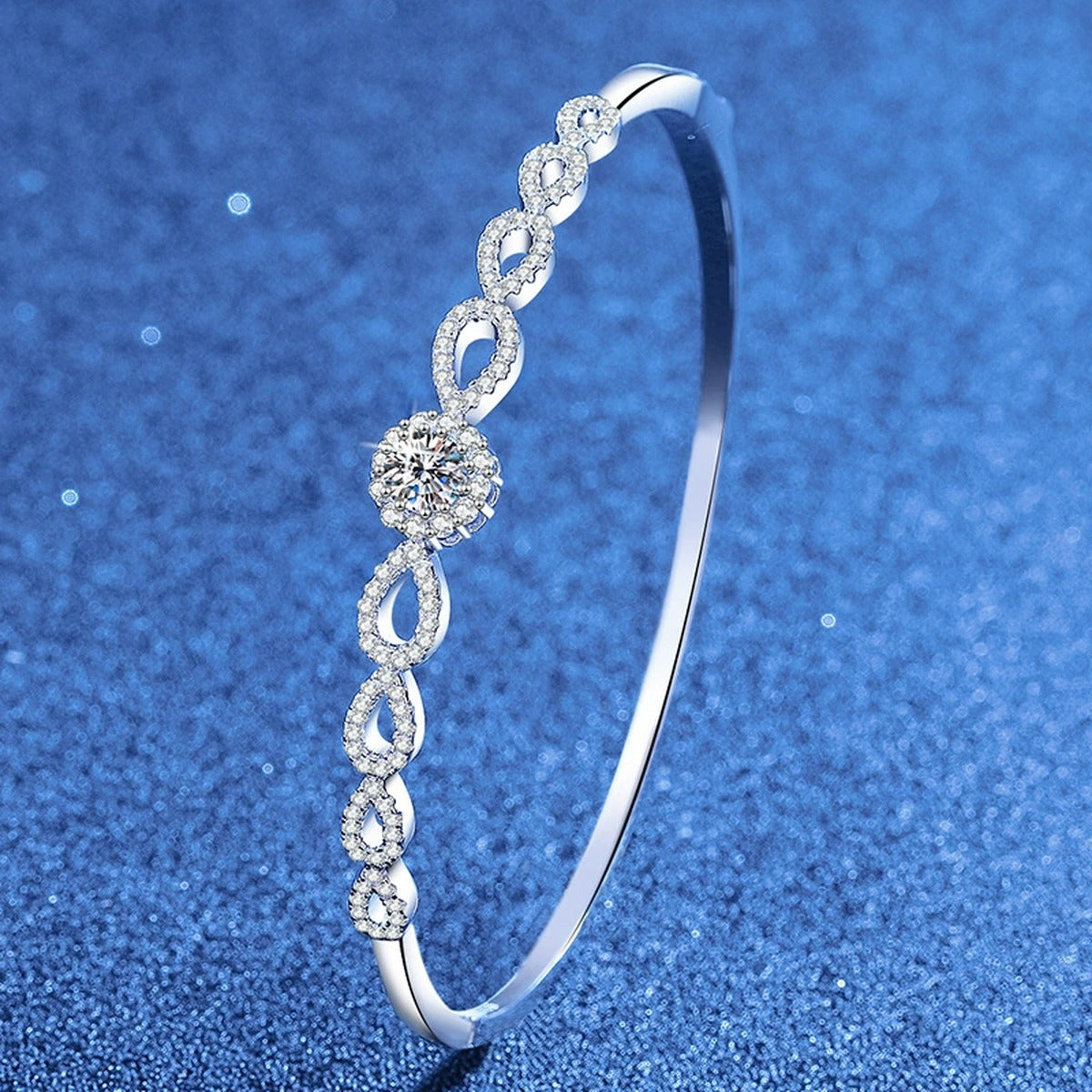 Round Moissanite Bangle Bracelet with CZ styled on blue display background showing moissanite sparkle and chain detail