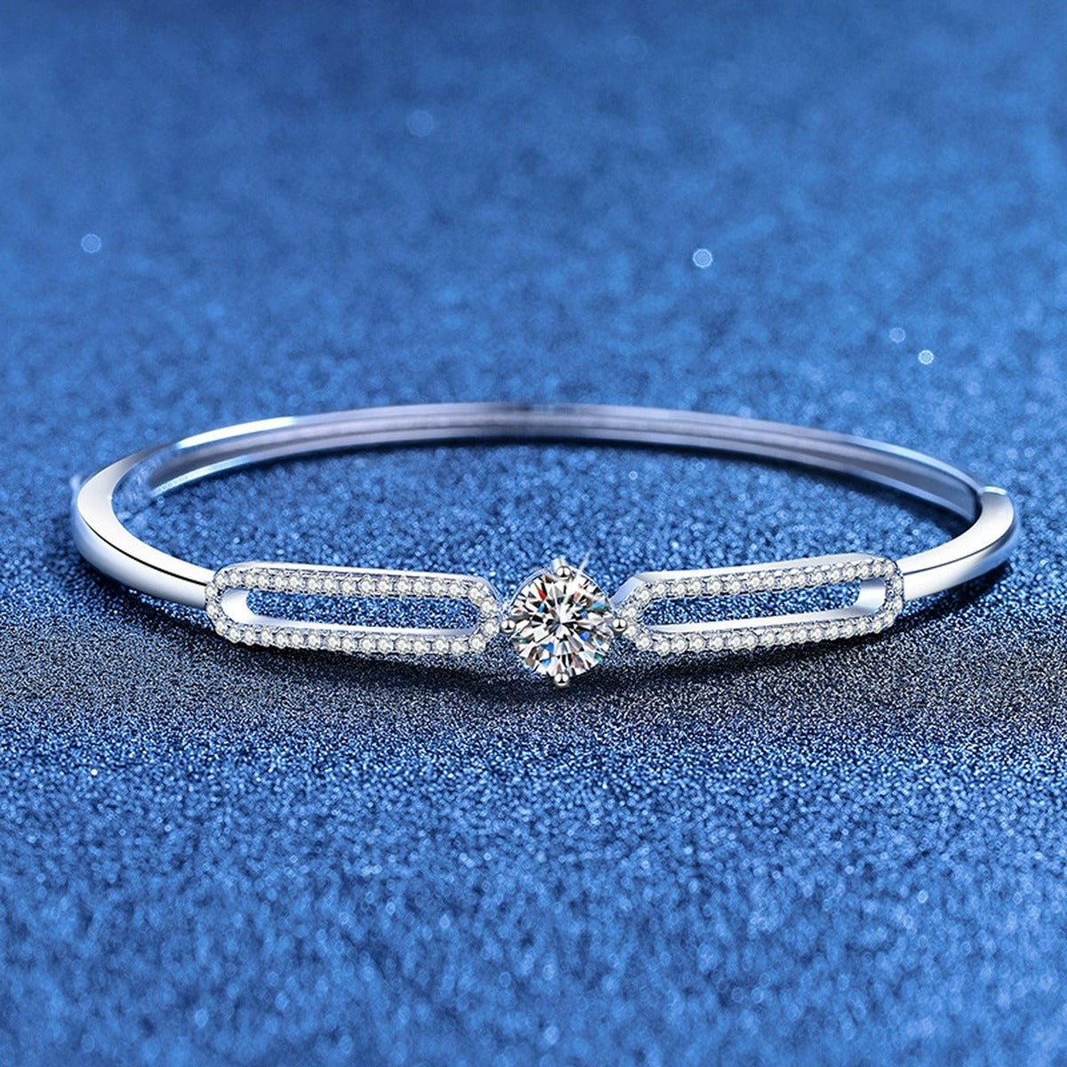 Paperclip Moissanite Bangle Bracelet with CZ styled on blue display background showing moissanite sparkle and chain detail