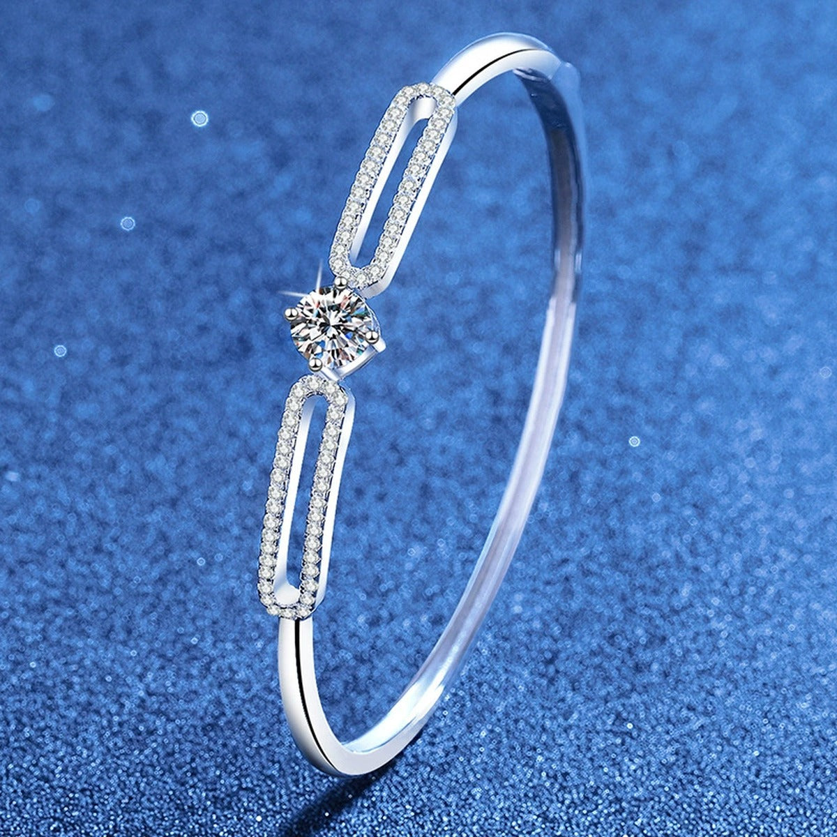 Paperclip Moissanite Bangle Bracelet with CZ styled on blue display background showing moissanite sparkle and chain detail
