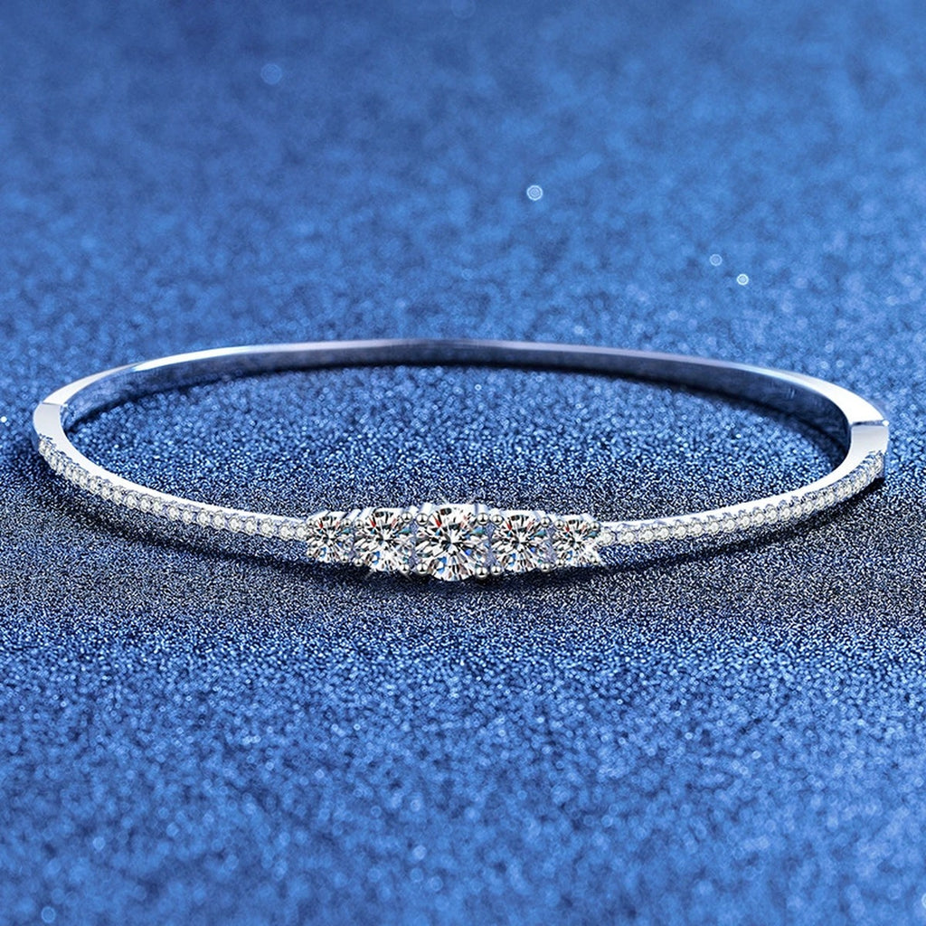 Graduated Moissanite Bangle Bracelet with CZ styled on blue display background showing moissanite sparkle and chain detail