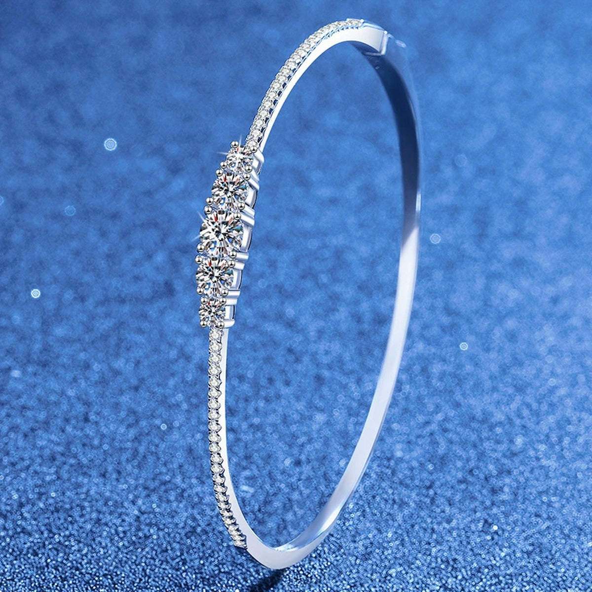 Graduated Moissanite Bangle Bracelet with CZ styled on blue display background showing moissanite sparkle and chain detail