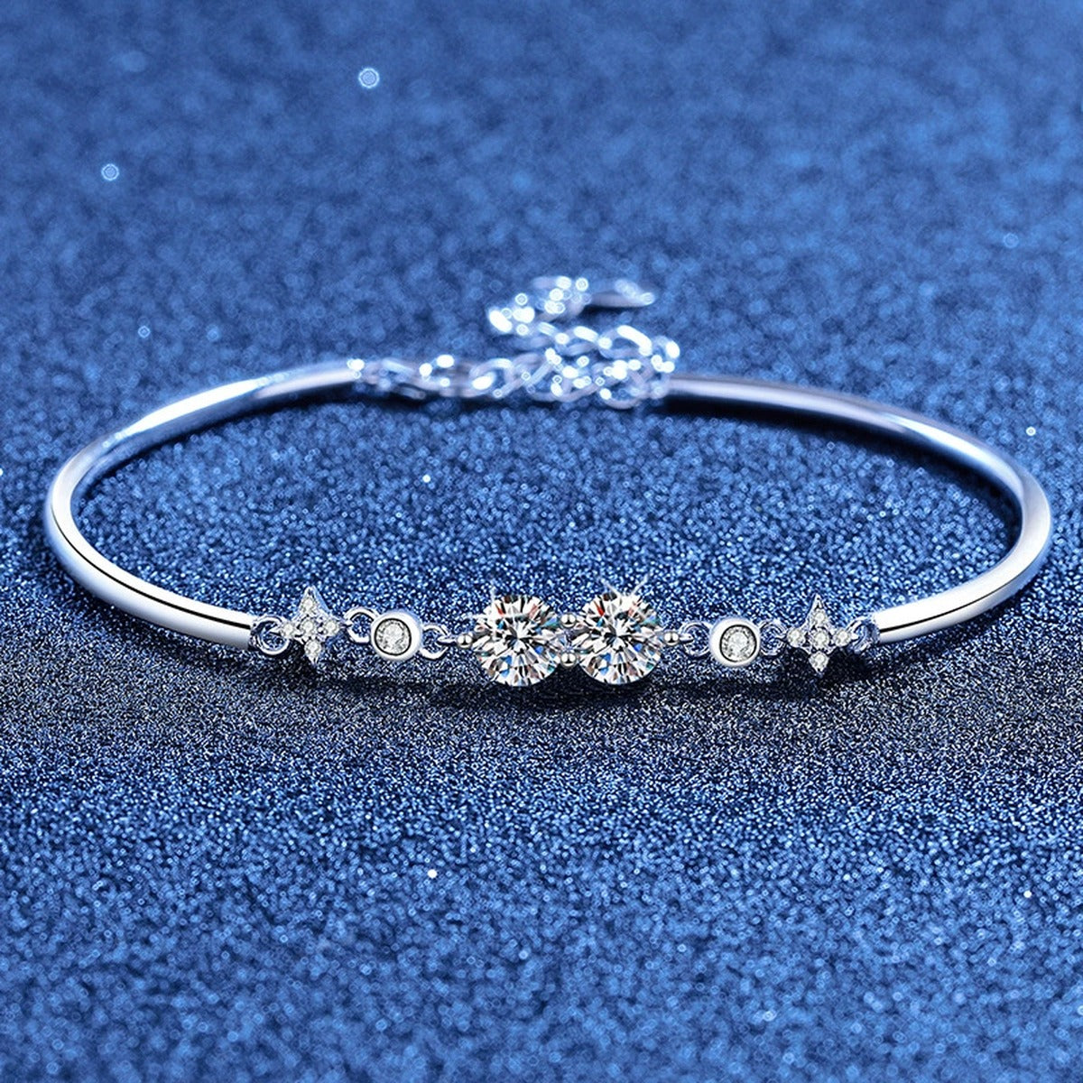 Round Moissanite Adjustable Bangle Bracelet with CZ styled on blue display background showing moissanite sparkle and chain detail