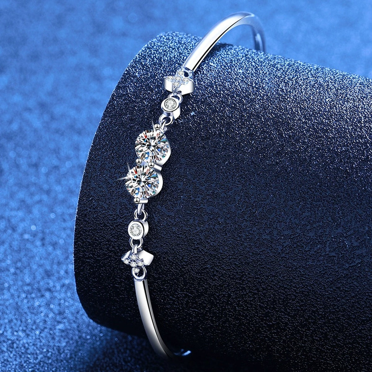 Round Moissanite Adjustable Bangle Bracelet with CZ styled on blue display background showing moissanite sparkle and chain detail