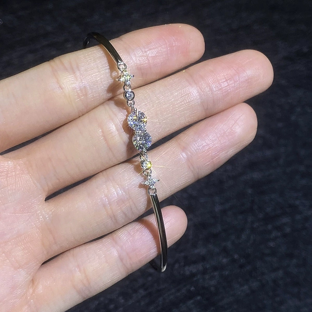 Round Moissanite Adjustable Bangle Bracelet with CZ hand-held close-up showing stone detail, width, and bracelet finish