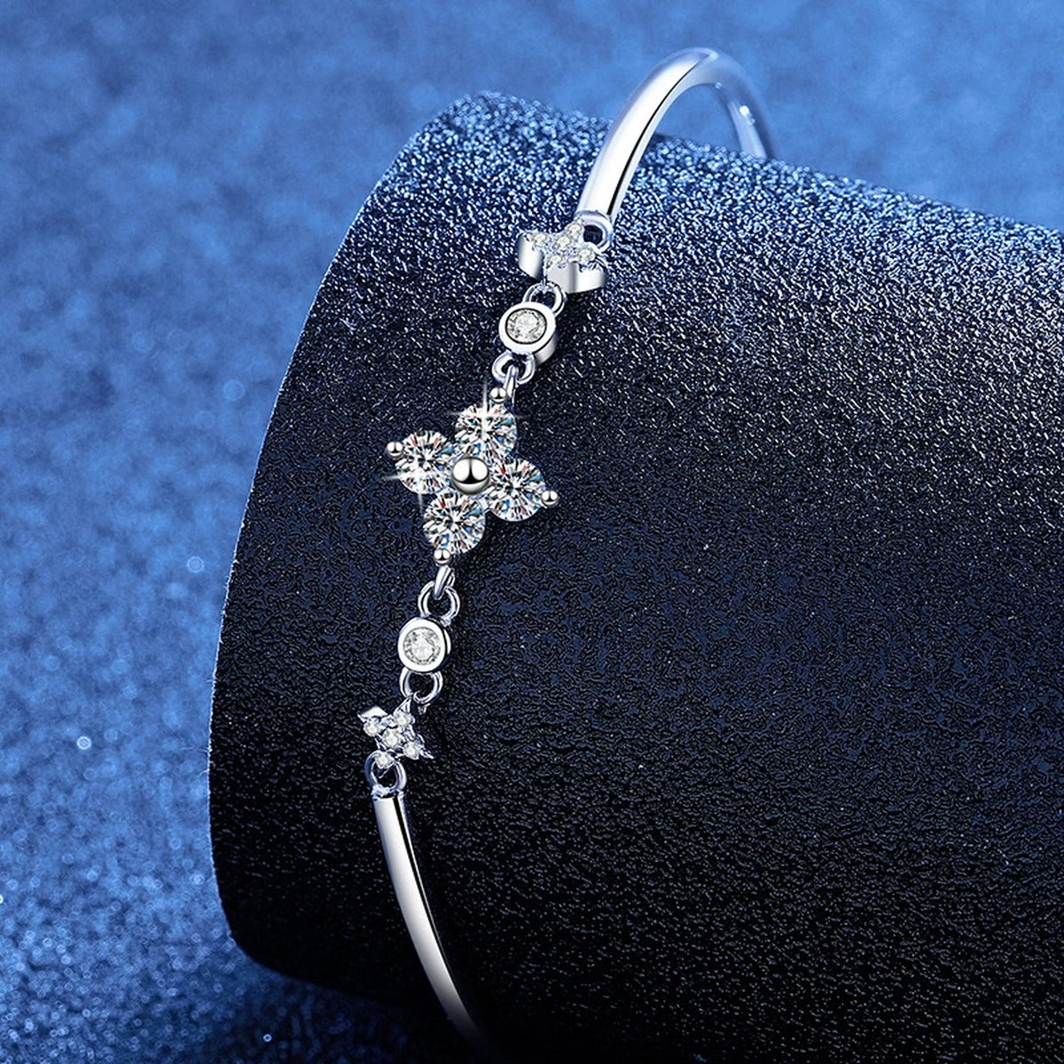 Floral Moissanite Adjustable Bangle Bracelet with CZ styled on blue display background showing moissanite sparkle and chain detail