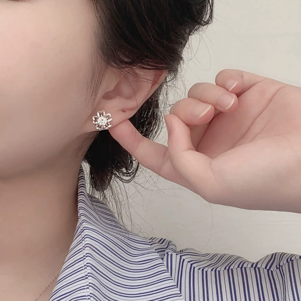 Cherry Blossom Round Moissanite Stud Earrings in White Gold-Plated S925 sterling silver worn on ear by model showing scale, placement, and stud earrings styling