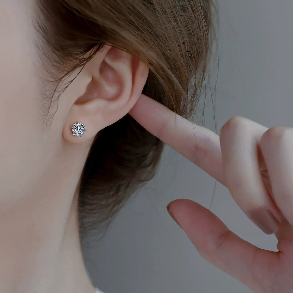Six-Prong Colored Moissanite Stud Earrings in Gold-Plated S925 sterling silver worn on ear by model showing scale, placement, and stud earrings styling