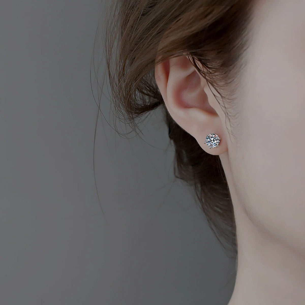 Six-Prong Colored Moissanite Stud Earrings in Gold-Plated S925 sterling silver worn on ear by model showing scale, placement, and stud earrings styling
