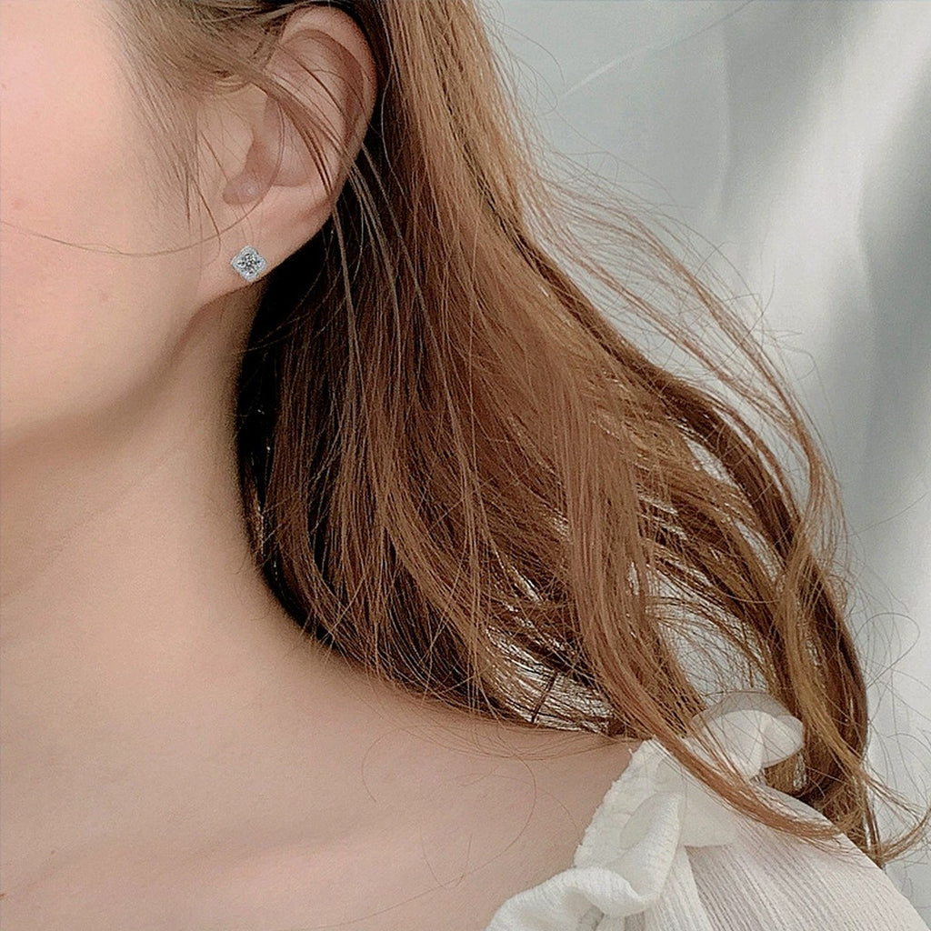 Four-Leaf Clover Round Moissanite Stud Earrings with CZ in White Gold-Plated S925 sterling silver worn on ear by model showing scale, placement, and stud earrings styling