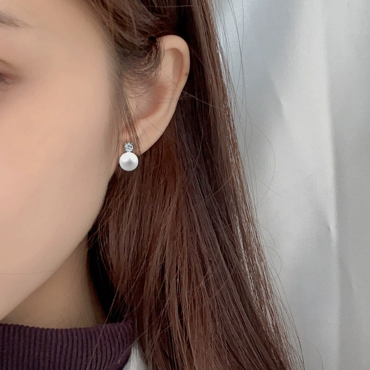Round Moissanite and Pearl Stud Drop Earrings in White Gold-Plated S925 sterling silver worn on ear by model showing scale, placement, and stud earrings styling