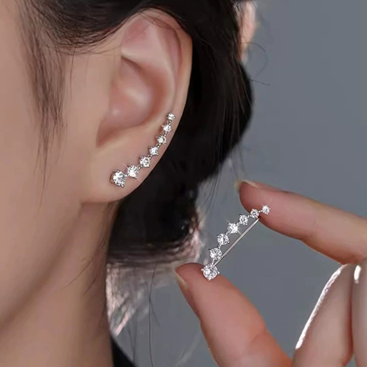 Graduated Round Moissanite Ear Climber Earrings in White Gold-Plated S925 sterling silver worn on ear by model showing scale, placement, and earrings styling