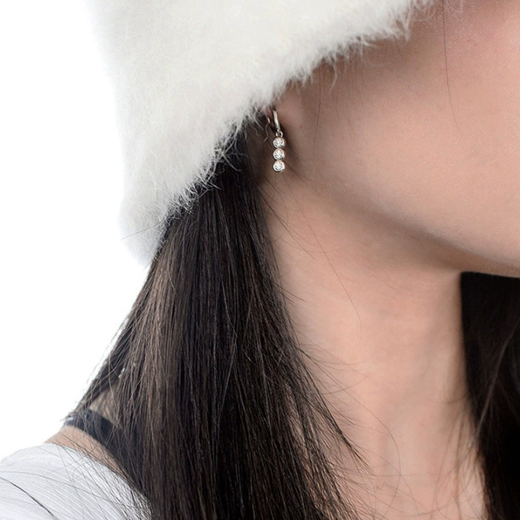 Graduated Round Moissanite Hoop Dangle Earrings in White Gold-Plated S925 sterling silver worn on ear by model showing scale, placement, and hoop dangle earrings styling