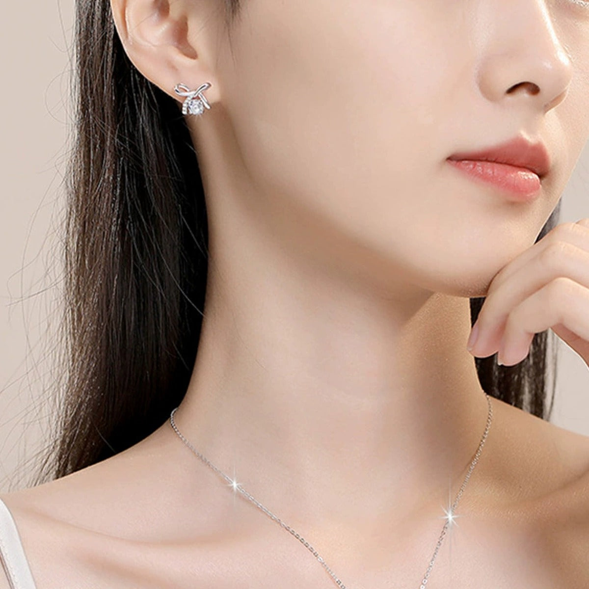 Ribbon Bow Round Moissanite Stud Earrings with CZ in Gold-Plated S925 sterling silver worn on ear by model showing scale, placement, and stud earrings styling